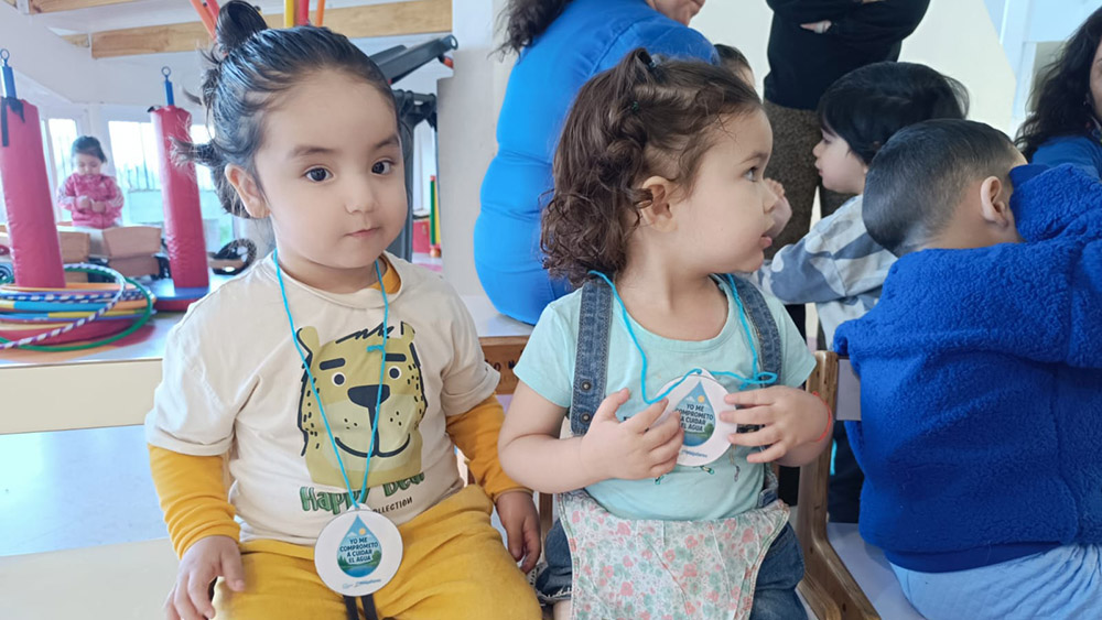 Niños y niñas reciben una medalla por su participación en la actividad.